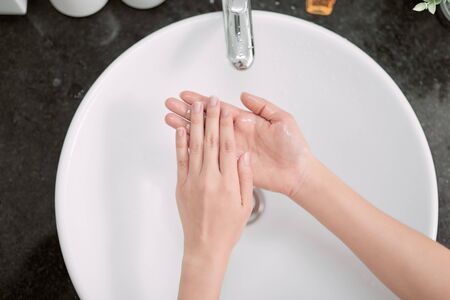 A woman washing hand on the sinkの写真素材