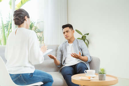 Psychologist consulting and psychological therapy session. Man in stress emotionally telling about...