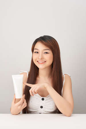Beautiful Young Asian Woman holding luxury white clean tube smile feeling so happy and cheerfulの写真素材