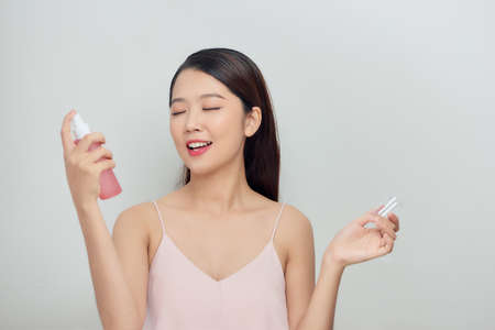 Beautiful woman face spray on face lotion cosmetology on white background isolationの写真素材