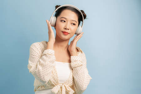 Picture of pretty woman in casual clothing looking on camera while enjoying melody via modern...
