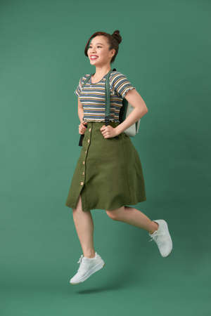 Indoor picture of young good-looking teenage girl isolated on green background,