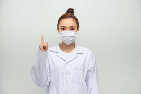 Young doctor woman showing and lifting a finger in sign of the bestの写真素材