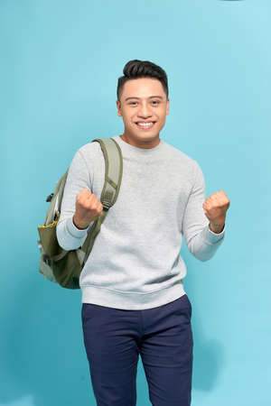 Happy successful student, business man winning, fists pumped celebrating success isolated blue...