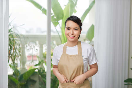 Young woman in apron at homeの写真素材