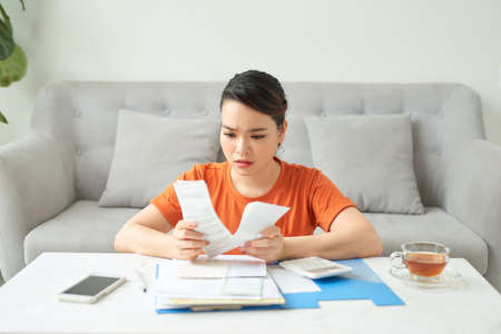 young woman calculates monthly expensesの写真素材