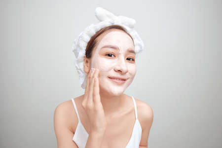 Woman on a white background clean face cream on face towel in hair on headの写真素材