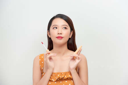 Cute girl applying lip gloss