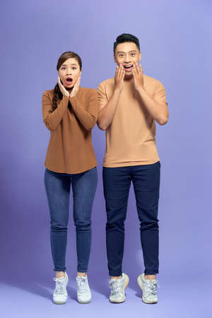 Image of happy friends loving couple standing isolated over purple background screaming looking...