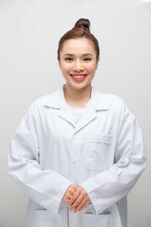 Young attractive asian woman in a white coat