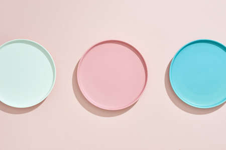 Pink, light blue, blue, pastel color plates set isolated on pinkの写真素材