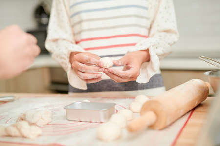 Making dough by female hands on wooden table backgroundの写真素材