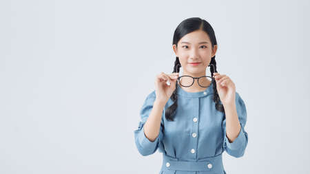 Beauty portrait of a young black healthy woman holding glasses and looking at cameraの写真素材