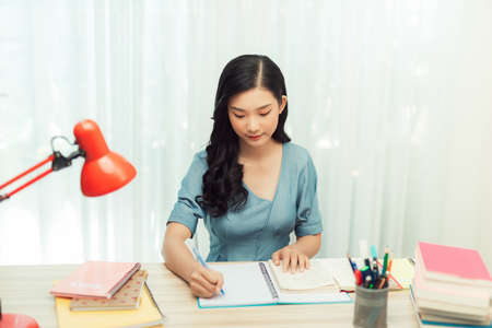 teenager college student doing research homework assignment making notes learning