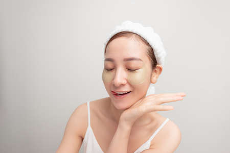 Indoor shot of calm relaxed woman has fresh healthy skin, wears collagen patches under eyesの写真素材