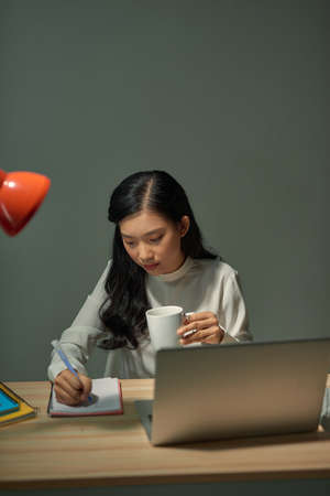 Smiling Asian girl having online classes at home