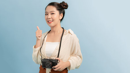 Woman traveler with a camera, blue backgroundの写真素材
