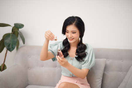 Pretty young woman showing how hyaluronic acid looks like isolated. Female using anti age product .