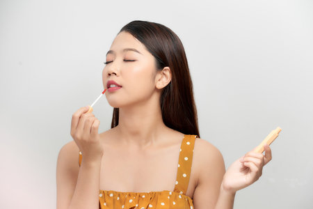 Portrait with copyspace empty place for product of cute, charming joyful girl testing new lip glossの写真素材