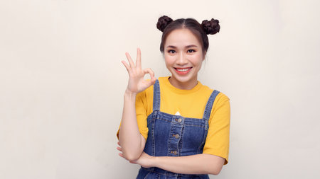 lifestyle, emotion and people concept: Portrait of a happy young girl showing ok gesture and...