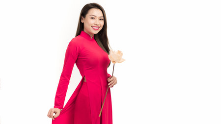 Attractive happiness young Vietnamese woman in ao dai dress carrying lotus flower
