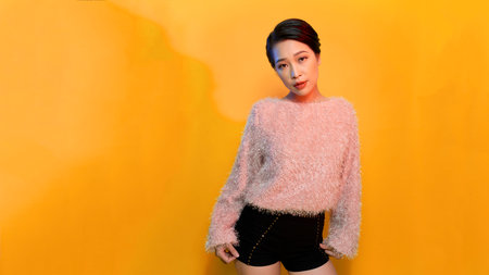 Portrait of young pretty girl dressed in a pink sweater.の写真素材