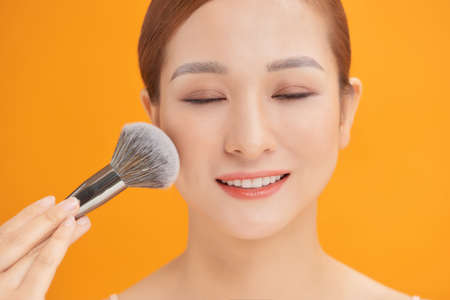 woman applying powder to clean her face skin.