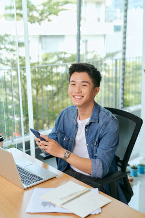 Young asian business men working with laptop phone in coffee shop cafe.の写真素材