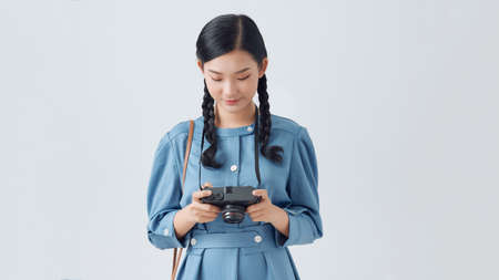 Beautiful smiling asian woman with photo cameraの写真素材