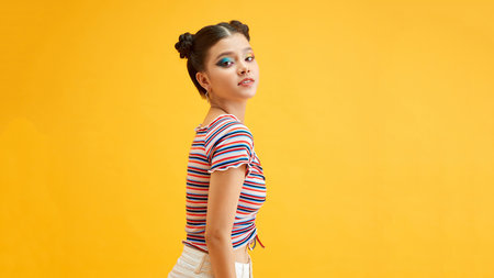 Naughty lady with bright makeup and smiles on yellow backgroundの写真素材