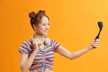 Young female blogger with recording video with smartphone, making vlog.の写真素材