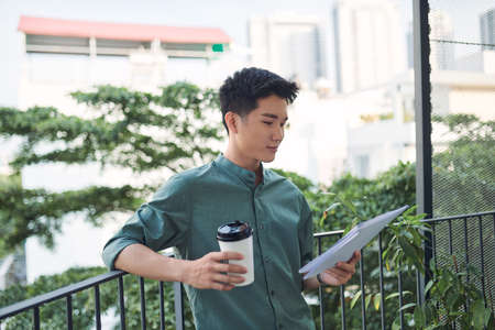 Young attractive businessman holding documents, papersの写真素材
