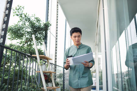 Business man reading files outdoors.