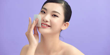 beauty skin care woman smile and using facial oil blotting paperの写真素材