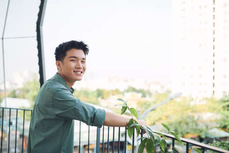 Young asian guy waiting and leaning in hand rail