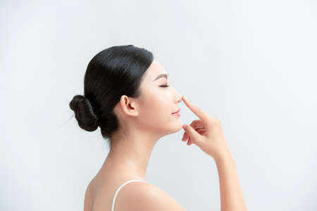 Side profile of asian lady pointing her noseの写真素材