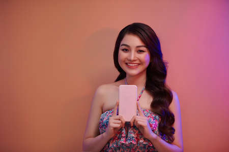 Smiling young woman girl posing isolated in neon light studio portraitの写真素材