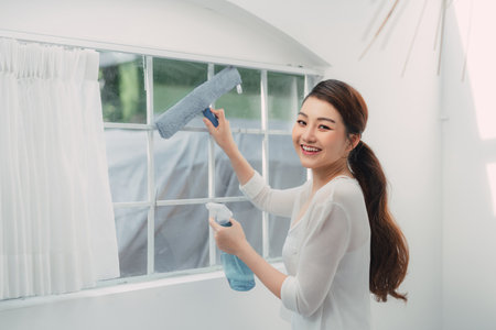 Woman cleaning window at home, closeup. Household chores