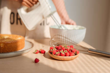 Kitchen mixer whips cream to make sponge cake or red velvet cake.の写真素材