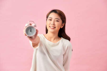 asian beautiful girl holding classic alarm clock