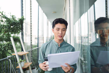 Young attractive businessman holding documents, papersの写真素材