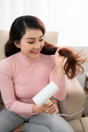 Healthy girl with hair dryer isolatedの写真素材