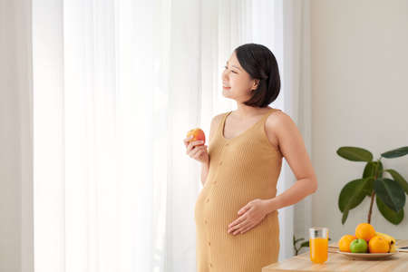 Beautiful young pregnant woman with apples. health care and beautyの写真素材