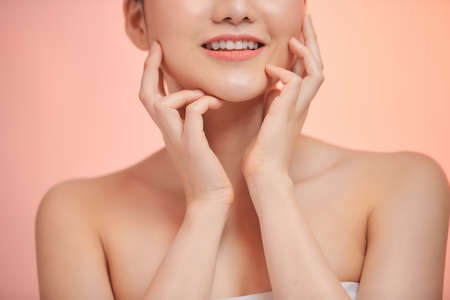 young and happy girl with light make-up and closed eyes touching her chin and smilingの写真素材