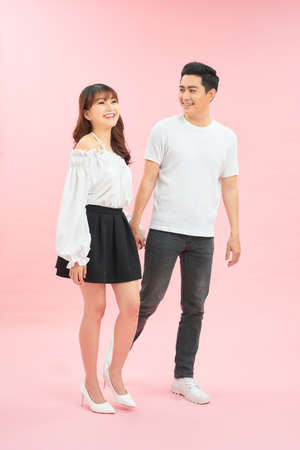 Young emotional man and woman in casual clothes on pink backgroundの写真素材