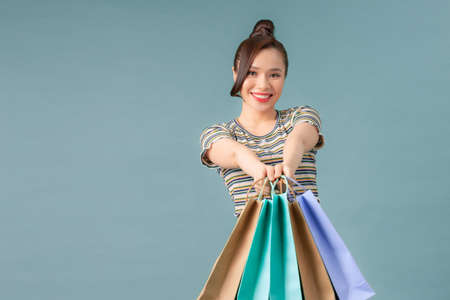 Portrait of young happy smiling woman with shopping bagsの写真素材