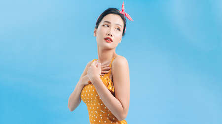 Slender female model in a yellow polka dot dress goes on a date