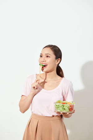 Attractive young woman eating saladの写真素材