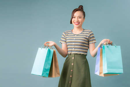 Portrait of young happy smiling woman with shopping bagsの写真素材
