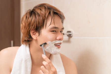 Man shaving in the bathroom.の写真素材